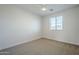 Simple bedroom with a large window, neutral carpet, a ceiling fan, and minimal design at 3128 E Cheryl Dr, Phoenix, AZ 85028
