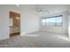 Bright and spacious primary bedroom features neutral carpet, a ceiling fan, and an adjacent bathroom at 3128 E Cheryl Dr, Phoenix, AZ 85028