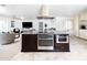A modern kitchen features a large island with stainless steel appliances, a range hood, and a view of the living room at 3726 S Juniper St, Tempe, AZ 85282