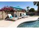 Relaxing poolside with lounge chairs, turquoise accents, vibrant flowers, and a calming umbrella at 3726 S Juniper St, Tempe, AZ 85282