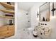 Modern bathroom featuring stylish vanity, walk-in shower with glass enclosure, and floating wood shelves at 3744 N Rock Wren Ct, Buckeye, AZ 85396