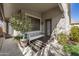 A serene patio featuring a bench, striped rug, tasteful decor, and a potted tree offers an inviting outdoor space at 38075 N Bonnie Ln --, San Tan Valley, AZ 85140