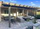 Under-pergola view of backyard with a covered outdoor kitchen and outdoor seating at 385 N Mataclor Ct, Casa Grande, AZ 85194