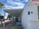 Exterior view of a mobile home featuring covered parking and a small outdoor patio at 4065 E University Dr # 271, Mesa, AZ 85205