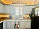 Quaint kitchen featuring light blue cabinets, laminate countertops, and black appliances at 4065 E University Dr # 271, Mesa, AZ 85205