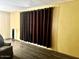 Living room with wood laminate flooring and custom full wall length dark brown curtains at 4065 E University Dr # 271, Mesa, AZ 85205