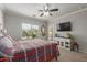 Well-lit bedroom featuring a ceiling fan, large window, and a television set at 4830 S Grenoble --, Mesa, AZ 85212