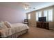 Cozy bedroom with a ceiling fan, plantation shutters, and a dresser with TV at 5110 W Sweet Iron Pass, Phoenix, AZ 85083