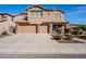Two-story house featuring a two-car garage, neutral stucco, stone accents and long concrete driveway at 5110 W Sweet Iron Pass, Phoenix, AZ 85083