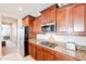 Gourmet kitchen with stainless steel appliances, wooden cabinets, granite countertops, and tile floors at 5110 W Sweet Iron Pass, Phoenix, AZ 85083
