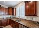 Kitchen featuring stainless steel appliances, wooden cabinets, granite countertops, a sink, and tile floors at 5110 W Sweet Iron Pass, Phoenix, AZ 85083