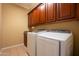 Convenient laundry room with a front load washer and dryer and upper cabinets at 5110 W Sweet Iron Pass, Phoenix, AZ 85083
