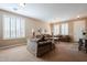 Spacious living room with plush sofas, a glass coffee table, neutral carpet and shuttered windows at 5110 W Sweet Iron Pass, Phoenix, AZ 85083