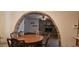 View of dining room with hardwood table, brick archway to living room with brick fireplace at 610 E Ironwood Dr, Buckeye, AZ 85326