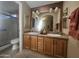 Bathroom with double sinks, wood cabinets, large mirror, and enclosed shower area at 650 N Hawes Rd # 4834, Mesa, AZ 85207