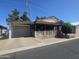 Charming single-story home with a covered porch, attached garage, and manicured landscaping at 650 N Hawes Rd # 4834, Mesa, AZ 85207