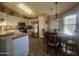 Bright kitchen with a dining area, skylight, white cabinetry, stainless steel appliances and tiled floors at 650 N Hawes Rd # 4834, Mesa, AZ 85207
