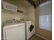 A well-lit laundry room with a washer, dryer, shelving and a window at 650 N Hawes Rd # 4834, Mesa, AZ 85207