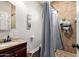 Bathroom showcasing a tiled shower with a grey curtain and vanity sink at 6935 N Valley Rd, Eloy, AZ 85131