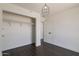 Bedroom featuring dark wood floors, closet and a modern light fixture at 743 E Holmes Ave, Mesa, AZ 85204