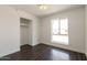 Sunlit bedroom with dark wood-look floors and closet at 743 E Holmes Ave, Mesa, AZ 85204