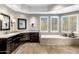 Bathroom featuring dual sinks, a large soaking tub, and wood-look tile floors at 9370 E Calle De Las Brisas --, Scottsdale, AZ 85255