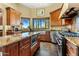 Bright kitchen with stainless steel appliances, granite counters, island, and windows showcasing desert views at 9370 E Calle De Las Brisas --, Scottsdale, AZ 85255