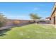 Fenced backyard with synthetic grass, gravel, and mature foliage at 9743 E Torino Ave, Mesa, AZ 85212