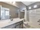 Bathroom features gray cabinets, chrome hardware, a white tub and shower, and tiled floors at 9743 E Torino Ave, Mesa, AZ 85212