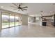 Open living room featuring tiled floors, ceiling fan, and glass sliding doors leading to a green backyard at 9743 E Torino Ave, Mesa, AZ 85212