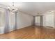 Bright, empty living room with wood floors, a chandelier and large windows offering plenty of natural light at 991 E Monteleone St, San Tan Valley, AZ 85140