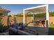 Enjoy outdoor living under the modern pergola with a built-in grill and inviting seating at 10136 E Sphere Ave, Mesa, AZ 85212