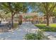 View of the pool gate with a covered stone structure surrounded by lush trees and landscaping at 10757 N 74Th St # 1016, Scottsdale, AZ 85260