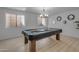 Billiards table with a chandelier and blinds-covered windows in a game room at 137 W Gary Way, Gilbert, AZ 85233