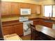Efficient kitchen featuring wood cabinets, white appliances, and ample counter space for meal preparation at 13819 W Berridge Ln, Litchfield Park, AZ 85340