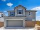 Charming two-story home with a gray exterior and well-manicured front yard with a two car garage at 14634 W Sand Hills Rd, Surprise, AZ 85387