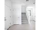 Hallway boasts light tile flooring, white doors, and leads to stairs at 14634 W Sand Hills Rd, Surprise, AZ 85387