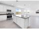 Bright kitchen featuring white cabinets, granite countertops, stainless steel appliances, and center island at 14634 W Sand Hills Rd, Surprise, AZ 85387