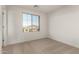 Bright bedroom featuring neutral carpet, a window with a view, and a closet at 18433 W Monte Lindo Ln, Surprise, AZ 85387