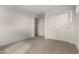 A minimalist carpeted bedroom with white walls and double doors, offering a blank canvas for personalization at 18433 W Monte Lindo Ln, Surprise, AZ 85387