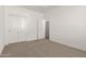 The bedroom has neutral carpet, white walls, closet with sliding doors, and white trim at 18433 W Monte Lindo Ln, Surprise, AZ 85387