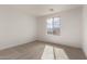 Bright bedroom with carpet and a view outside through a large window at 18433 W Monte Lindo Ln, Surprise, AZ 85387