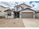Two-story home boasts a neutral color scheme, two car garage, and desert landscaping at 18433 W Monte Lindo Ln, Surprise, AZ 85387