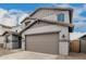 The two-story home boasts a two car garage and architectural details, and desert landscaping at 18433 W Monte Lindo Ln, Surprise, AZ 85387