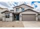 Two-story home boasts a neutral color scheme, two car garage, and desert landscaping at 18433 W Monte Lindo Ln, Surprise, AZ 85387