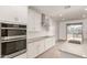 Modern kitchen with stainless appliances, gray counter tops and plenty of white cabinets at 18433 W Monte Lindo Ln, Surprise, AZ 85387