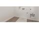 Laundry room with wood-look tile floors and white walls at 18433 W Monte Lindo Ln, Surprise, AZ 85387