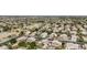 A wide aerial view of a suburban neighborhood with neatly arranged homes and lush landscaping under a bright sky at 2032 E Sierra Madre Ave, Gilbert, AZ 85296