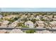 Aerial view of a residential area with a mix of houses, trees, and streets under a partly cloudy sky at 2032 E Sierra Madre Ave, Gilbert, AZ 85296