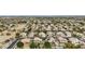 A high-angle shot of a residential neighborhood with varied houses, mature trees, and distant mountains under a bright sky at 2032 E Sierra Madre Ave, Gilbert, AZ 85296